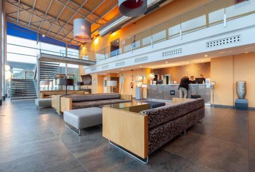 a lobby with couches and tables in a cafeteria at Hotel Palau de Bellavista Girona by URH in Girona