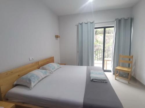 1 dormitorio con 1 cama, 1 silla y 1 ventana en Luz d'Sol - Residencial Familiar en Pombas