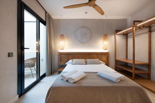 a bedroom with a large bed with towels on it at Apartamentos Balisse in Castelldefels