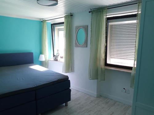 a bedroom with a bed and two windows at Casa Livia in Lieser