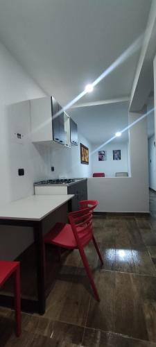 a kitchen with a table and a red chair at El buen descanso in Fusagasuga