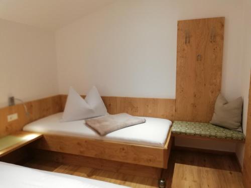 a wooden bed with two pillows on top of it at Appartement Seppenbauer - Seppenbauerhof in Heiligenblut