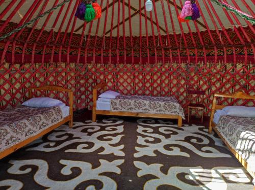 um quarto com duas camas numa tenda em Eco Village Lodge em Dzhetyoguz