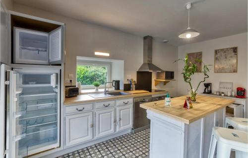 a kitchen with white cabinets and a wooden counter top at 3 Bedroom Cozy Home In Baraqueville in Baraqueville