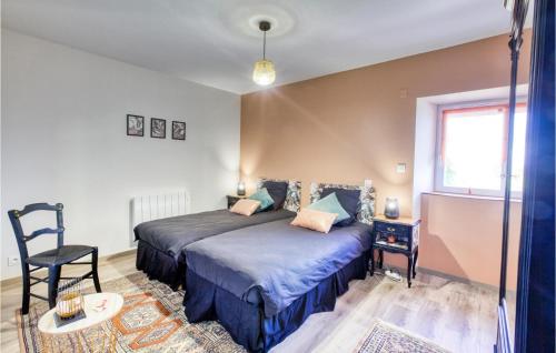 a bedroom with a bed and a chair and a window at 3 Bedroom Cozy Home In Baraqueville in Baraqueville