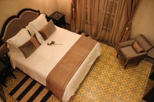 a bedroom with a large bed and a chair at Dar Souran in Tangier