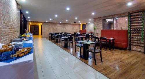 a restaurant with tables and chairs in a room at Hotel Madisson Inn Luxury By GEH Suites in Bogotá
