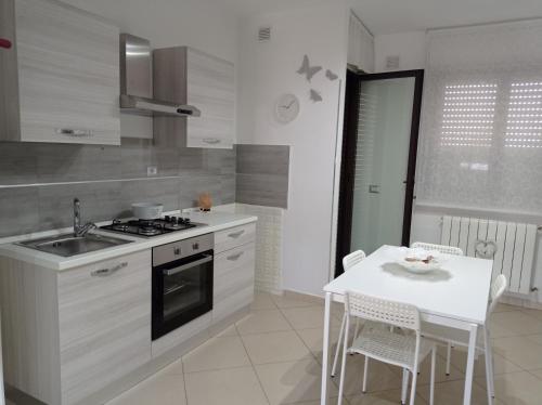 uma cozinha com um fogão e uma mesa com cadeiras em Casa vacanza Sofy em Brindisi