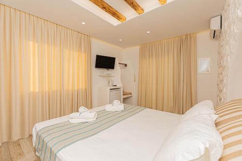 a bedroom with a bed with towels on it at Kallithea Hotel in Agia Anna Naxos