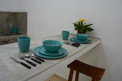 einem Tisch mit zwei blauen Schalen und Platten darauf in der Unterkunft Xula Bacalar in Bacalar