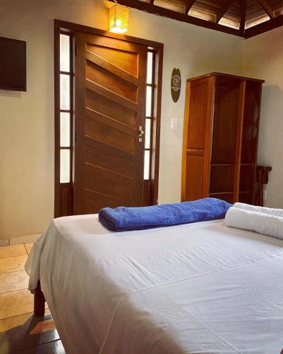 a bedroom with a large bed and a wooden door at Pousada OCEAN in Saquarema