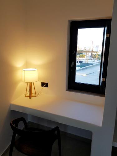 a table with a lamp and a window at myLithos Suites in Monolithos
