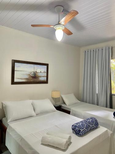 a bedroom with two beds and a ceiling fan at Pousada OCEAN in Saquarema