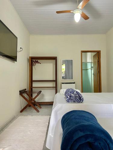 a bedroom with a bed and a ceiling fan at Pousada OCEAN in Saquarema