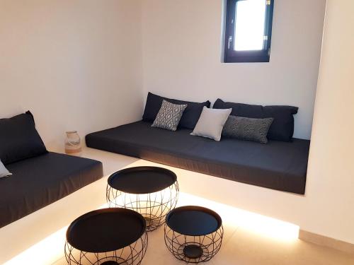 a living room with a couch and two chairs at myLithos Suites in Monolithos
