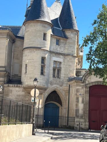 een kasteel met een blauwe deur ervoor bij MARAIS BRAQUE APPARTEMENT in Parijs