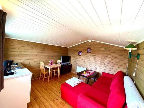 a living room with a red couch and a table at Aspnes Camping AS in Mosjøen
