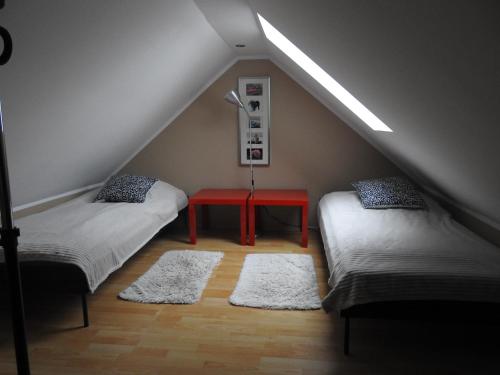 a attic room with two beds and a red table at apartament Jaśkowy in Żarnowska