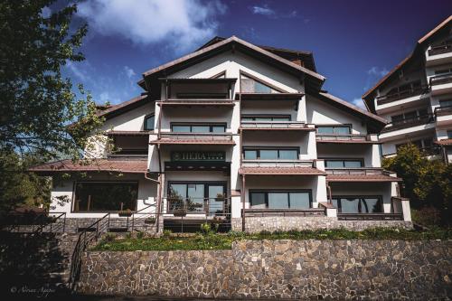 a large white building with a fence in front of it at Vila Hera Luxury in Predeal
