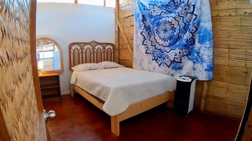 ein kleines Schlafzimmer mit einem Bett in einem Zimmer in der Unterkunft Casa Mauka Bungalow in Los Órganos