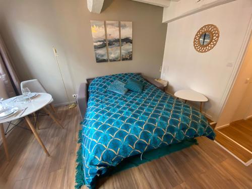 Schlafzimmer mit einem Bett mit blauer Decke in der Unterkunft Le studio bleu - studio hypercentre Rouen - 106 in Rouen
