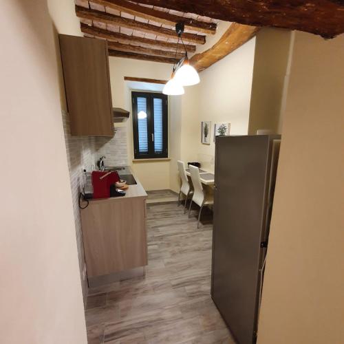 a kitchen with a refrigerator and a dining room at The View - Sunset & Relax - Suite - Appartamenti Vista Lago in Passignano sul Trasimeno