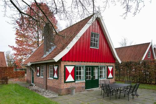 a red barn with a table in front of it at Vakantiehuis Schanszicht in Lievelde