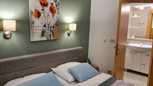 een kleine slaapkamer met een bed en een wastafel bij Villa Amalia Apartment 2 in Malinska