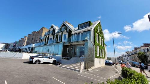 a building with a car parked in a parking lot at OYO Newquay Beach Hotel in Newquay