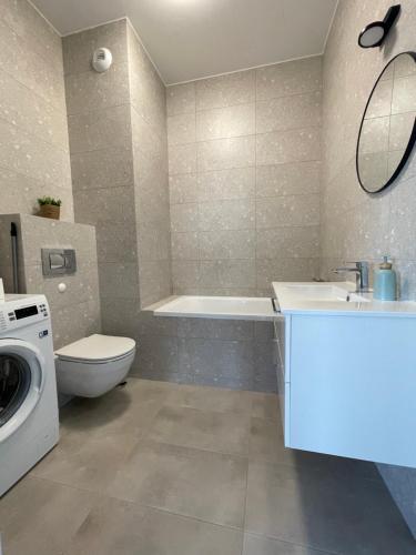 uma casa de banho com um lavatório e uma máquina de lavar roupa em Apartamenty Termalne na Długiej 8 em Uniejow