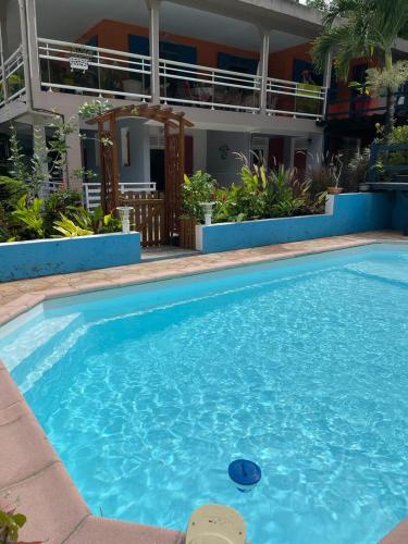a large blue swimming pool in front of a building at Bas de Villa ALPINIA au Gosier in Le Gosier