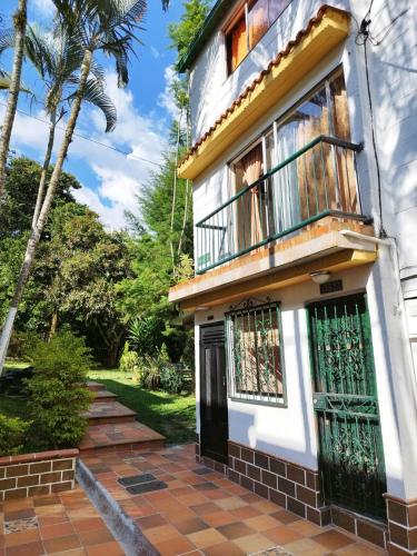 a white house with a balcony and a porch at Apartamento Quintas de San Javier in Medellín