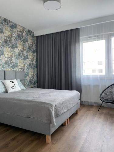 um quarto com uma cama grande e uma janela em Apartamenty Termalne na Długiej 8 em Uniejow