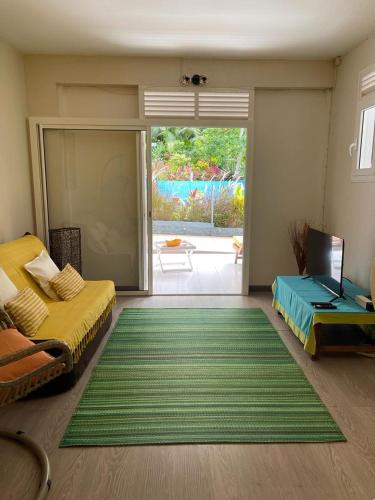 a bedroom with a bed and a green rug at Bas de Villa ALPINIA au Gosier in Le Gosier