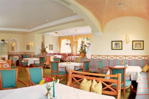 a restaurant with tables and chairs in a room at Wohlfühlresort und Feriengut Martinerhof in Sankt Martin am Tennengebirge