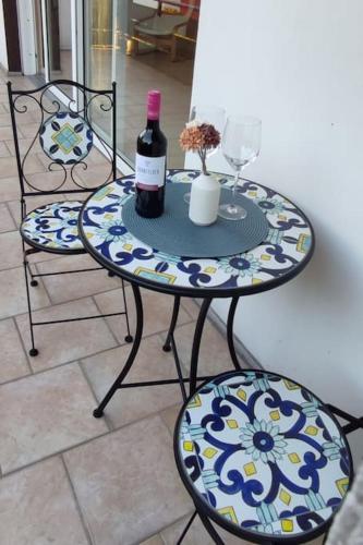 a table with a bottle of wine and two chairs at Top Ferienwohnung am Waldrand mit großem Balkon in Lübbecke
