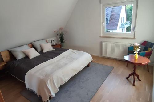 a bedroom with a bed and a table and a window at Top Ferienwohnung am Waldrand mit großem Balkon in Lübbecke