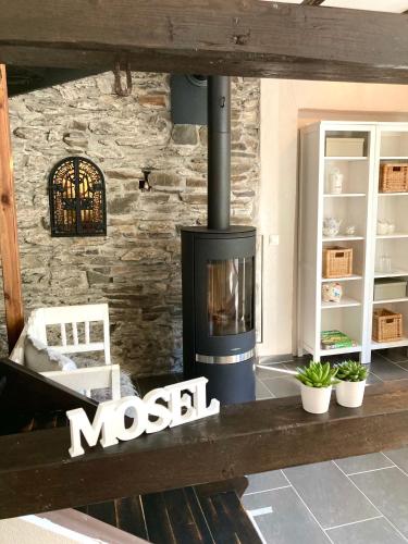a fireplace in a living room with a stone wall at Ferienhaus Goldstück wohnen im Weinberg in Pommern