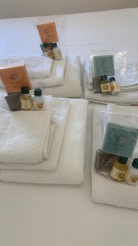 a group of white towels with bottles on them at Appartamento sul mare Nettuno in Nettuno