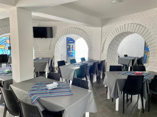 una sala da pranzo con tavoli e sedie e una TV di HOTEL CAASAMA a Santa María