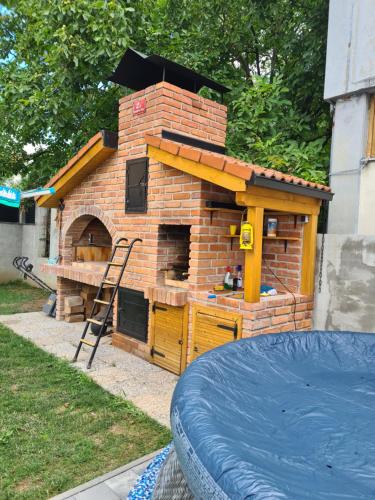 a brick oven in a backyard with a play structure at Apartment DINLUX in Maribor