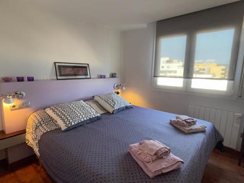 a bedroom with a bed with two towels on it at ROSAS Vue sur Mer in Roses