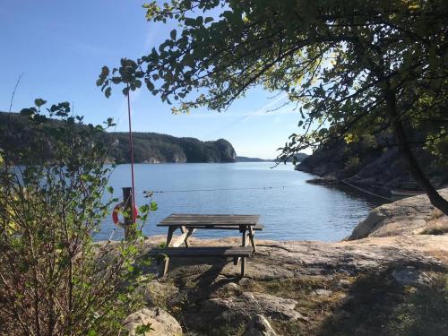 a picnic table on the shore of a lake at Bergsviksvägen 5, Munkedal in Munkedal
