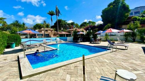 a swimming pool with chairs and umbrellas at a resort at Natal Prime Yacht Village in Natal