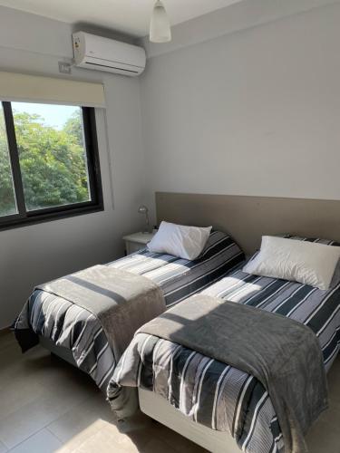 2 nebeneinander sitzende Betten in einem Schlafzimmer in der Unterkunft Bajada Vieja Departamentos in Posadas