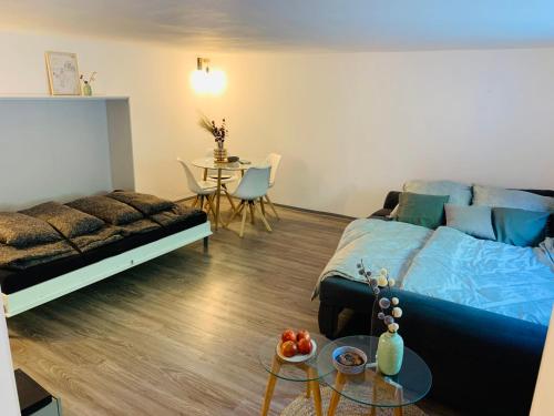 a living room with a bed and a table at Schickes Apartment mit direkter Waldrandlage in Geisenheim