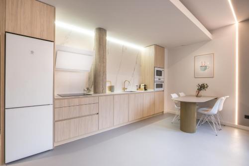 a kitchen with a table and a refrigerator at Bilbao Centric Apartments in Bilbao