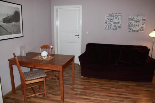 ein Wohnzimmer mit einem Tisch und einem Sofa in der Unterkunft Altes Zollhaus Stralsund in Stralsund