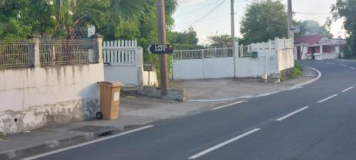 a sign on the side of a road next to a fence at Label kafé in Bouillante