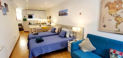 1 dormitorio con 2 camas y sofá azul en Cantinho do Auka - Studio, en Aveiro